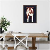 Framed illustration of a brown and white cow wearing glasses, centered on a dark navy background, hanging above a wooden dining table with white chairs.