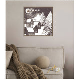 Monochrome framed canvas showing snowy rooftops, tall pine trees, a full moon, and Santa's sleigh flying across a starry night sky above a cozy village.