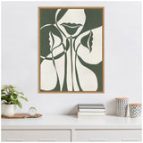 Abstract minimalist artwork in green and white showing stylized lips, faces, and floral shapes framed and hanging above a white sideboard with plant and decorative items.