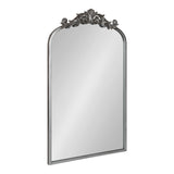 Rectangular mirror with an arched top and ornate dark metal floral decoration along the arch's peak