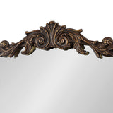 Curved mirror top with ornate dark brown decorative scrollwork and floral carvings in traditional baroque style