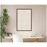 Framed linen fabric pinboard designed like a vintage library card with green lines and text, hanging on a beige wall above a minimalist desk with books and a plant.