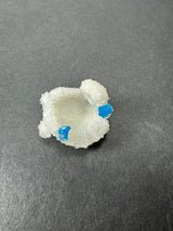 White stilbite crystal cluster with two bright blue cavansite ball formations on a dark gray background