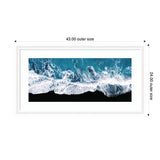 Aerial view of turquoise ocean waves crashing onto a stark black sand beach, framed in white with outer dimensions labeled 43 by 24 inches.