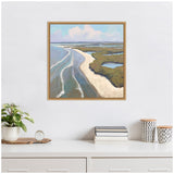 Framed landscape painting of a coastal scene with blue-gray water, sandy shore, and green marshlands under a sky with fluffy clouds, mounted above a white shelf.