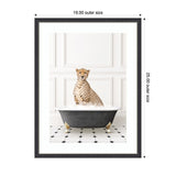 Framed print depicting a cheetah sitting upright in a black clawfoot bathtub filled with white foam on a black-and-white tiled floor against paneled white walls.
