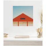 Framed square wall art showing a red triangular roof against a clear blue sky with a small black sign reading 'Hang Loose' centered on the roof's peak.