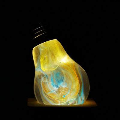 EP Light Firework Resin LED Bulb handcrafted with firework design in resin, shown with wooden base options