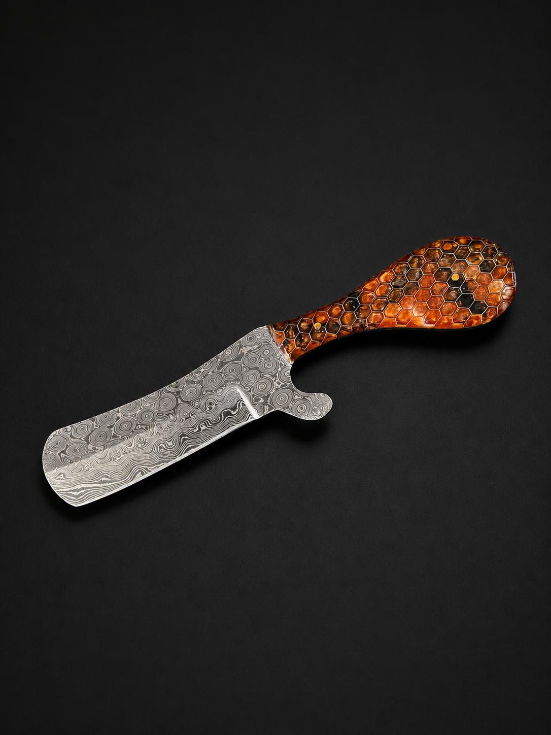 Straight-edged Damascus steel butcher knife with a patterned blade and an amber-colored honeycomb resin handle featuring black accents.