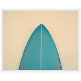 Top view of a teal surfboard nose with a white stringer, framed against a textured beige wall background.