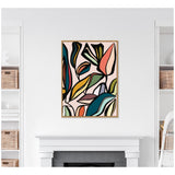 Abstract botanical-themed wall art in a light wood frame featuring colorful, overlapping organic shapes with muted earth tones and black outlines against a soft pink background.