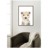 Framed whimsical polar bear illustration with large eyes and textured fur, accented by birch bark and small floral details, hanging above a dark green armchair with a knit throw.