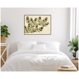 Framed botanical wall art above a white bed with soft pillows, featuring green leaves and pine cone shapes on a cream background, flanked by potted plants on woven stands.