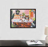 Framed colorful print of a cartoon tiger bathing in a tiger-striped tub filled with bubbles, surrounded by plants and orange towels in a bright bathroom scene.