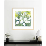 Framed watercolor of white hydrangea flowers with green and yellow foliage, displayed above a minimalist black console table with plants, books, and a white lamp.