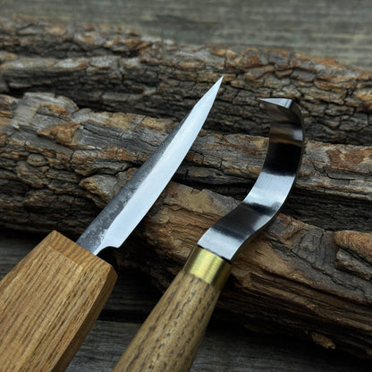 3-Piece Spoon Carving Tool Set with Leather Strop by Sharky Forged Steel Tools showing hook knife, sloyd knife, and leather strop on wooden surface