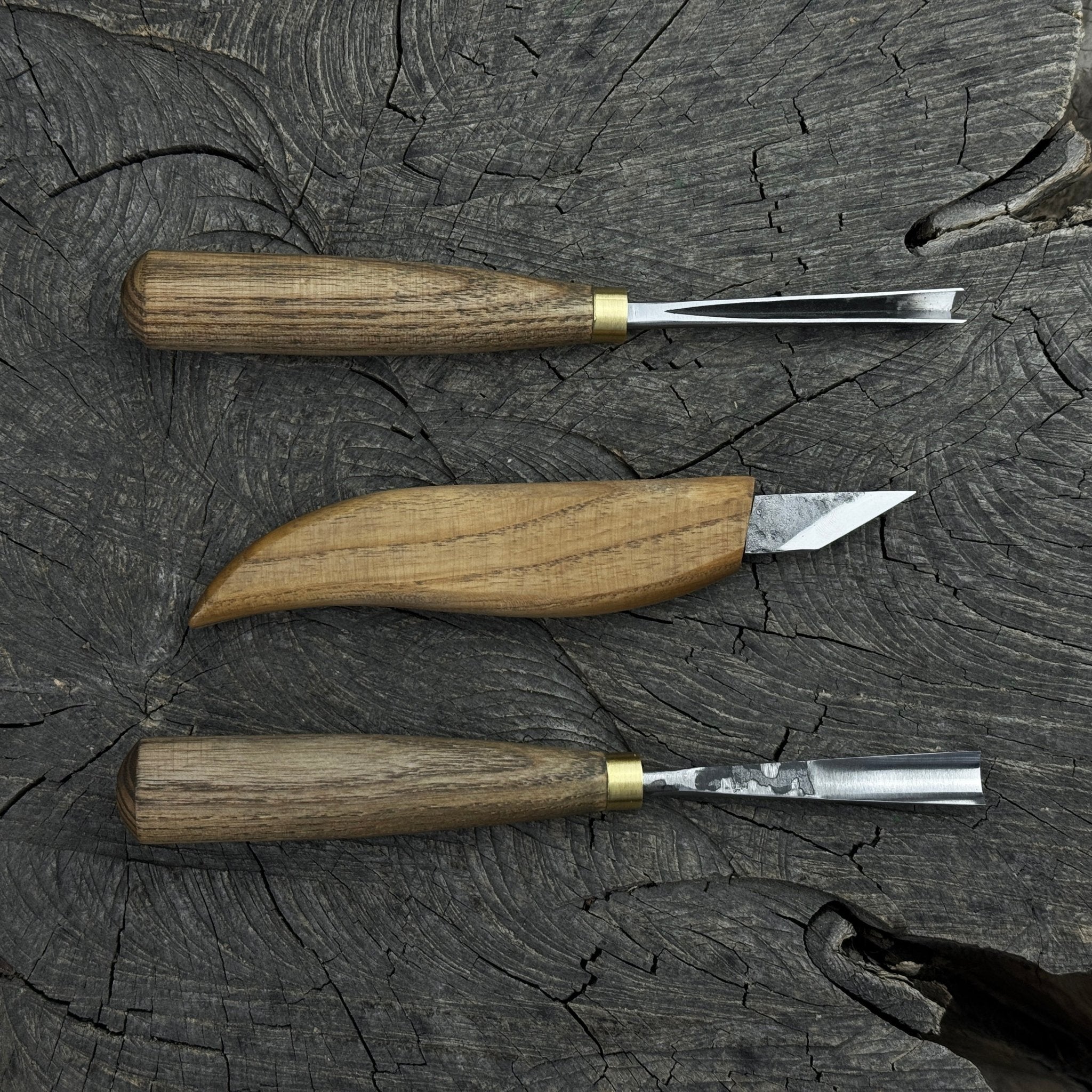 3-piece wood carving tool set with whittling knife, carving gouge, and V-parting chisel on a wooden surface
