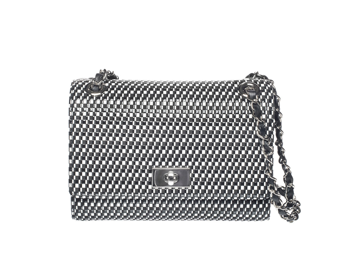 Black and white woven checkered shoulder bag with silver chain strap and rectangular turn-lock clasp on front flap.