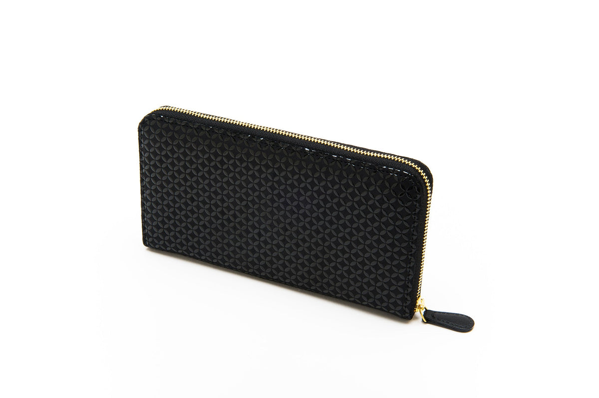 Black zipped long wallet with a repeating geometric pattern and gold-toned zipper hardware, shown at a slight angled side view on a white background.