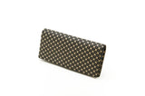 Rectangular long wallet with a black background and beige flower lattice pattern covering its surface, shown at a slight angle on a white background.