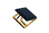 Compact rectangular mirror with a dark blue lid featuring a repeating petal pattern and a reflective gold frame inside.