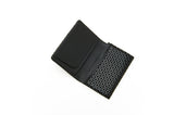 Open black business card case featuring a smooth interior pocket and an exterior flap with a geometric white dot pattern on black background.