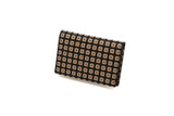 Rectangular business card case with black surface, adorned by a grid of bronze square studs featuring an X pattern, shown at a slight angle on white background.