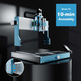 Compact desktop CNC router with aluminum frame, modular blue side panels, and spindle mounted on a horizontal gantry over a perforated work surface.