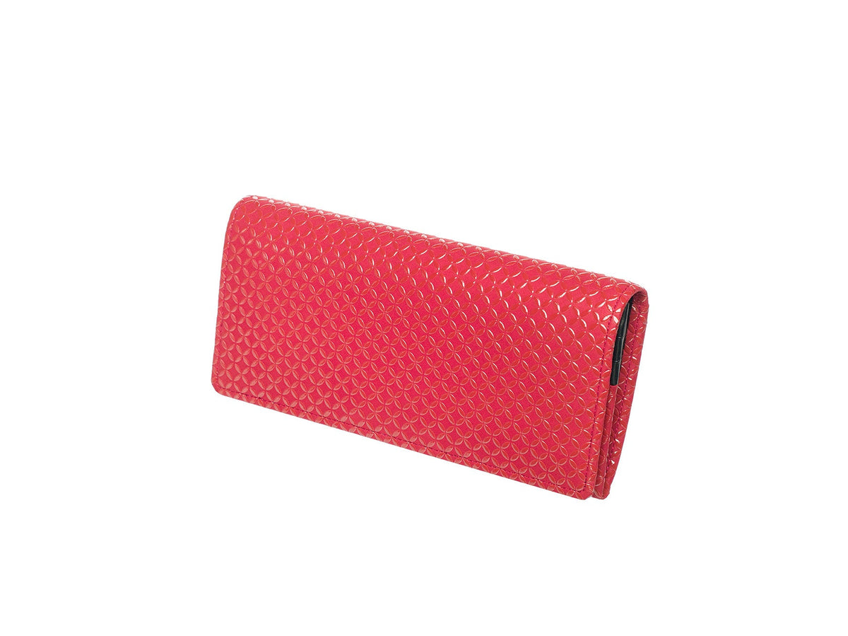 Rectangular long wallet in bright red with a repeating scale-like embossed pattern, shown closed at a slight angle against white background.
