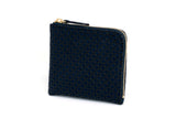 Compact navy blue coin purse with zip closure and subtle repeating geometric pattern, shown angled on white background.