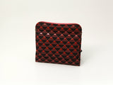 Compact coin purse with repeating triangular pattern in red and black, featuring a textured surface and a zippered side pocket, standing upright on a plain white background.