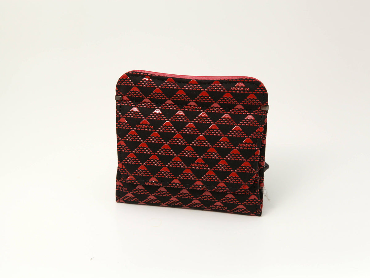 Compact coin purse with repeating triangular pattern in red and black, featuring a textured surface and a zippered side pocket, standing upright on a plain white background.