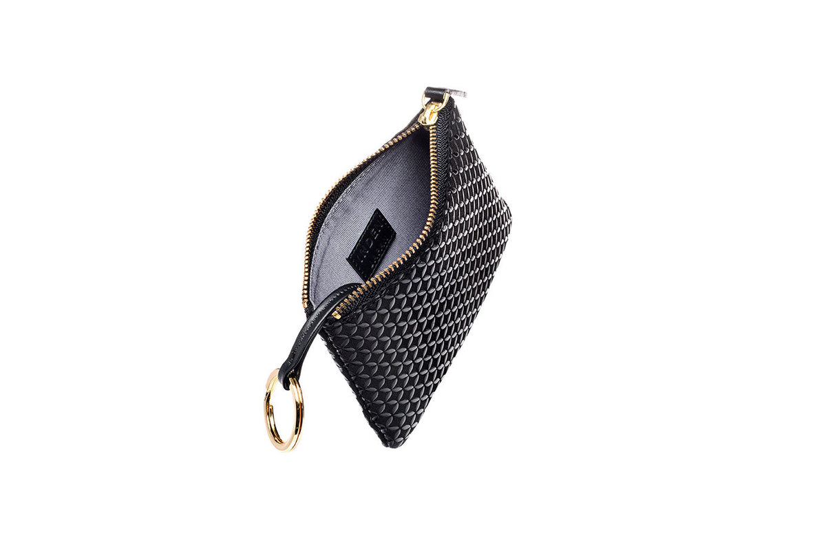 Black large key case with a textured woven pattern, gold zipper, and attached gold key ring, shown open with the interior fabric visible.