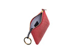Red textured zippered key case with gold-tone zipper and black leather strap attached to a gold key ring, shown partially open displaying light gray interior fabric.