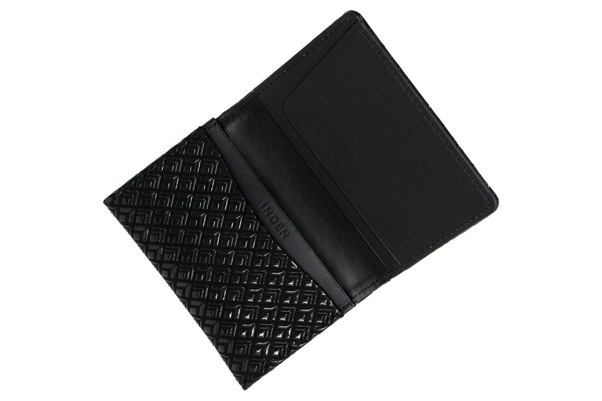 Open black business card case with a textured diamond pattern on one side and smooth interior card slots on the other.