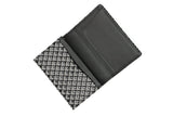 Open black business card case with white geometric chevron pattern on the exterior and plain black interior card slots.