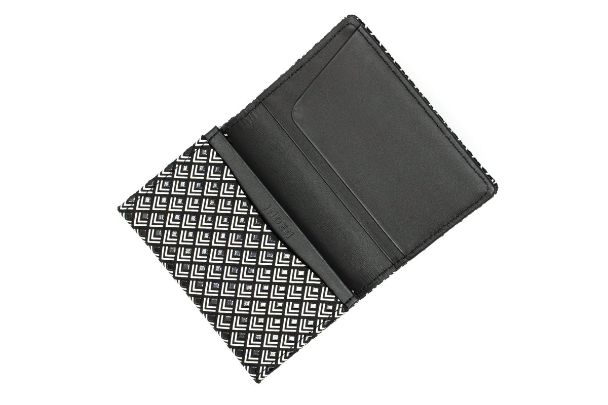 Open black business card case with white geometric chevron pattern on the exterior and plain black interior card slots.