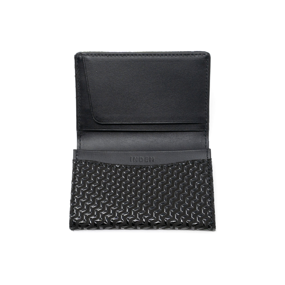 Black leather business card case with chevron pattern, open showing card slots