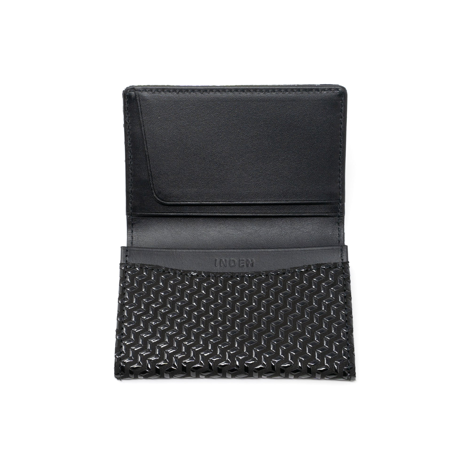 Black leather business card case with chevron pattern, open showing card slots