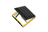 Black compact mirror with a diamond-patterned textured top and glossy black edges surrounding a gold-colored metal frame, shown open with reflective interior surfaces.
