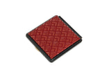 Square compact mirror with a red geometric diamond-patterned top and a black frame, shown closed against a white background.