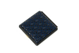 Square compact mirror with a black frame and dark blue diamond-patterned surface detail, viewed from above on a white background.