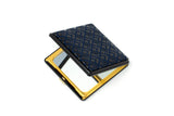 Square compact mirror with a dark blue diamond-patterned resin top and a gold metal frame, shown partially open to reveal the reflective surface inside.