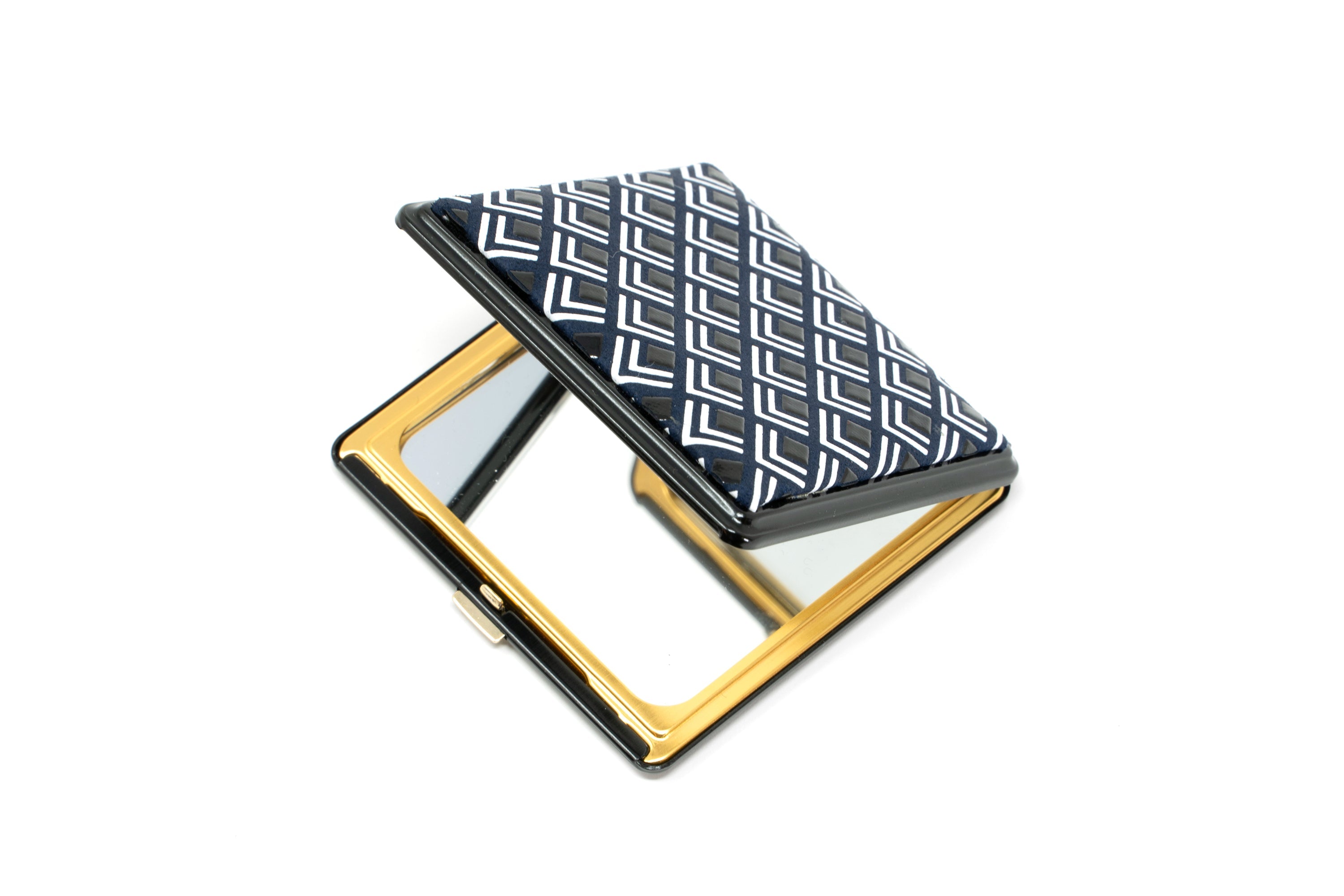 Double-faced compact mirror with white frame and black interior featuring standard and magnifying mirrors