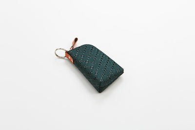 HISOKA Key Case in Black x Black and Green x Green colors, showing zipped leather cases with key rings