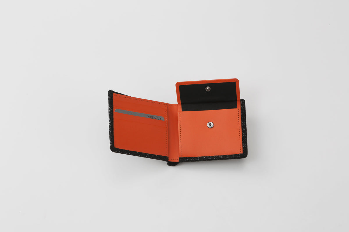 Open folded wallet with black exterior and bright orange interior, featuring a snap button coin pocket, card slots, and slim profile, shown on white background.