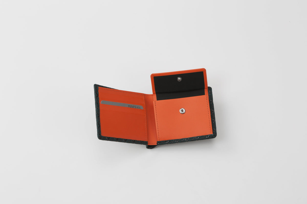 Partially opened bifold wallet with black exterior and vibrant orange interior featuring card slots and a snap-button coin pouch.