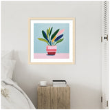Framed playful still life painting of a potted plant with green, navy, and pink leaves in a pink striped pot against blue and pink background, hanging above a wooden bedside table.