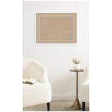 Rectangular cork pinboard with a white scalloped edge pattern, framed in white, mounted on a plain white wall above a brass side table and two cream upholstered chairs.