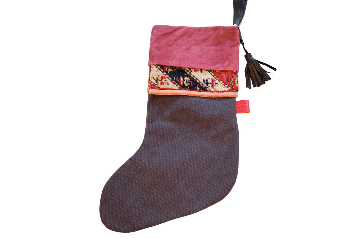 Antique Rug Fragment Stocking featuring a fuchsia suede cuff, leather tassel, and black linen back